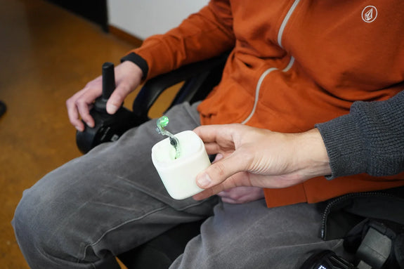 Person with disability and their MouthX being handed to them.